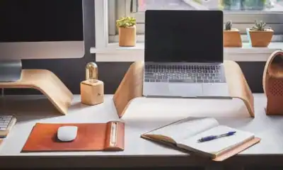- Arranjo de mesa com laptop, monitor e itens de escritório modernos.