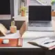 - Arranjo de mesa com laptop, monitor e itens de escritório modernos.