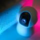 Fio de luz azul e rosa destacando projetor de alta tecnologia com iluminação LED.