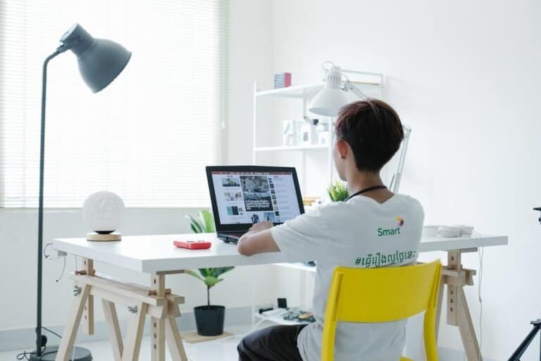 Tecnologia moderna em escritório com jovem usando laptop, produtividade digital, ambiente de trabalho clean.