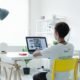 Tecnologia moderna em escritório com jovem usando laptop, produtividade digital, ambiente de trabalho clean.