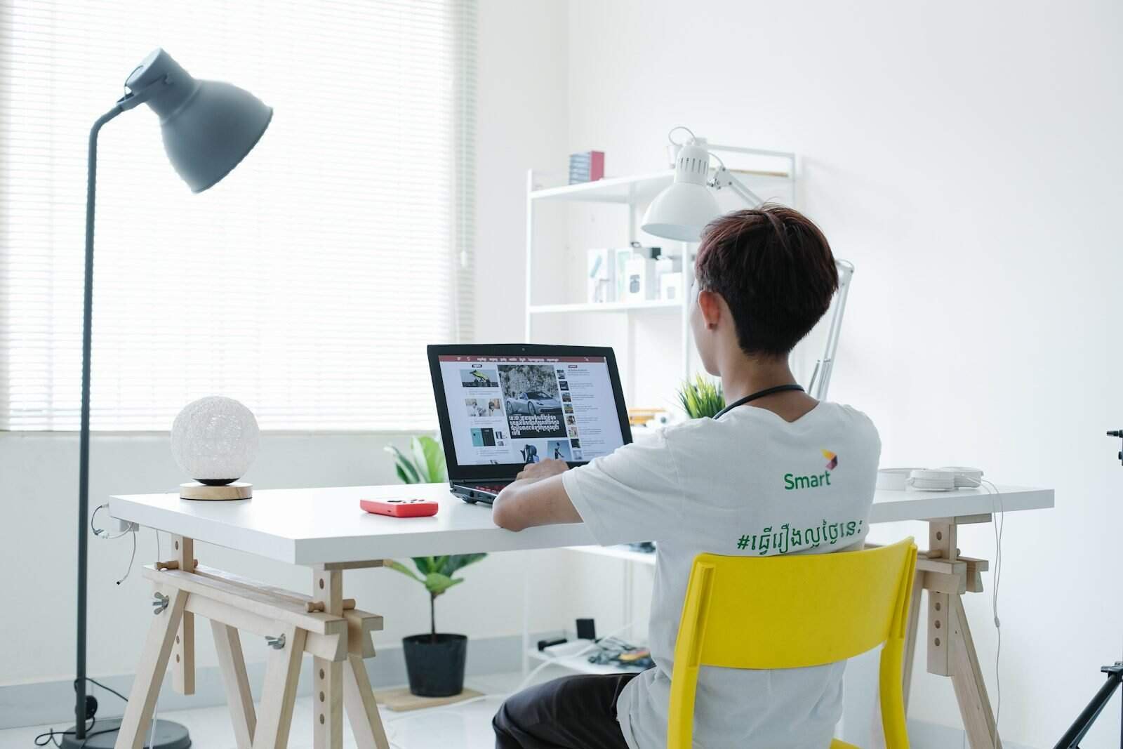 Tecnologia moderna em escritório com jovem usando laptop, produtividade digital, ambiente de trabalho clean.