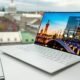 Laptop com tela exibindo previsão do tempo para Paris, França, em ambiente de escritório moderno.