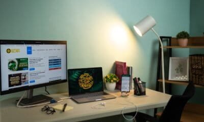 Monitores de computador em um escritório de casa com iluminação adequada.