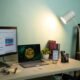 Monitores de computador em um escritório de casa com iluminação adequada.