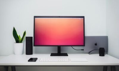 Monitor de computador com tela de fundo colorida e acessórios de tecnologia.