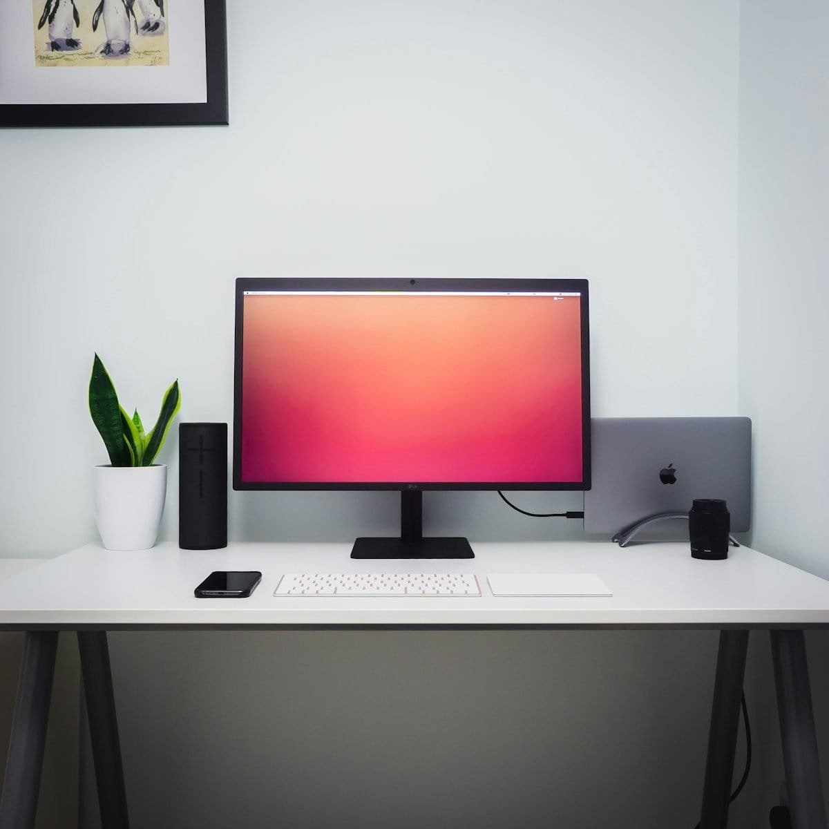 Monitor de computador com tela de fundo colorida e acessórios de tecnologia.