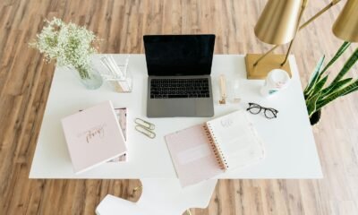 Cabine de escritório com laptop, livros e objetos decorativos elegantes.