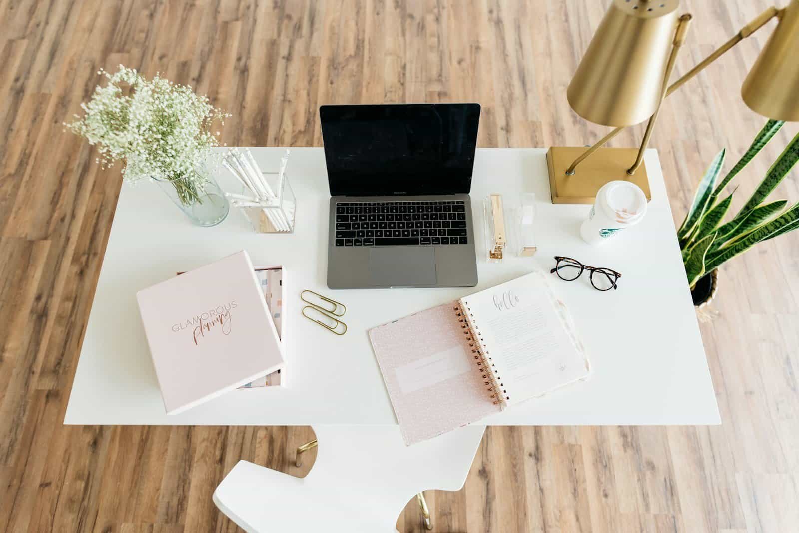Cabine de escritório com laptop, livros e objetos decorativos elegantes.