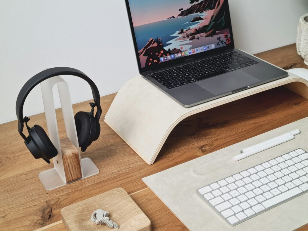 Headphones ao lado de um notebook em uma mesa de home office