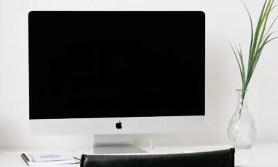 Impressora 3D em uma mesa de escritório com cadeiras confortáveis e decoração minimalista.