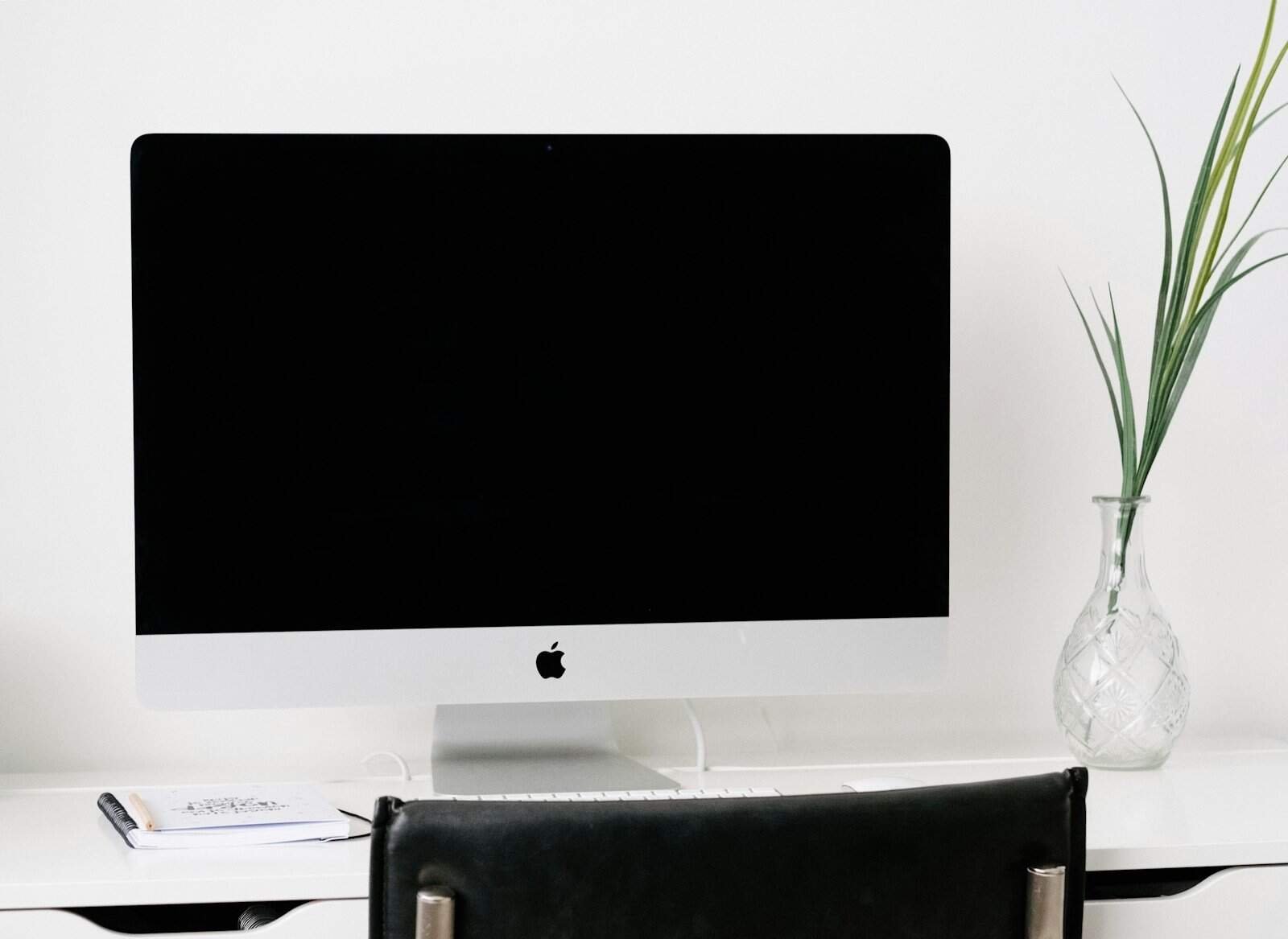 Impressora 3D em uma mesa de escritório com cadeiras confortáveis e decoração minimalista.