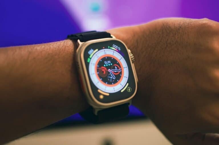 Carregador de smartwatch com pulseira preta em pulso humano.