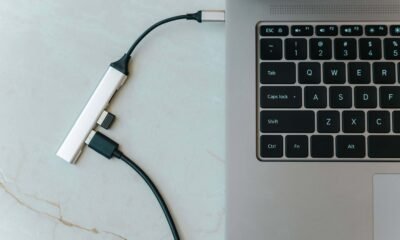 Conector USB-C tipo C ligado em laptop com teclado iluminado, tecnologia e inovação.