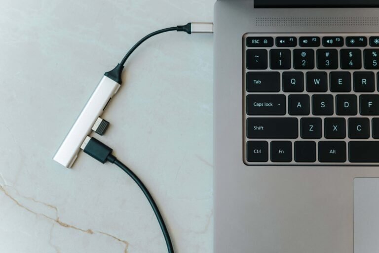 Conector USB-C tipo C ligado em laptop com teclado iluminado, tecnologia e inovação.