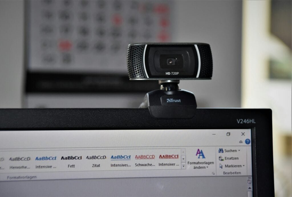 Webcam de alta definição conectada a um computador com software de edição de texto aberto, ideal para tecnologia, videoconferências e streaming.