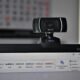 Webcam de alta definição conectada a um computador com software de edição de texto aberto, ideal para tecnologia, videoconferências e streaming.