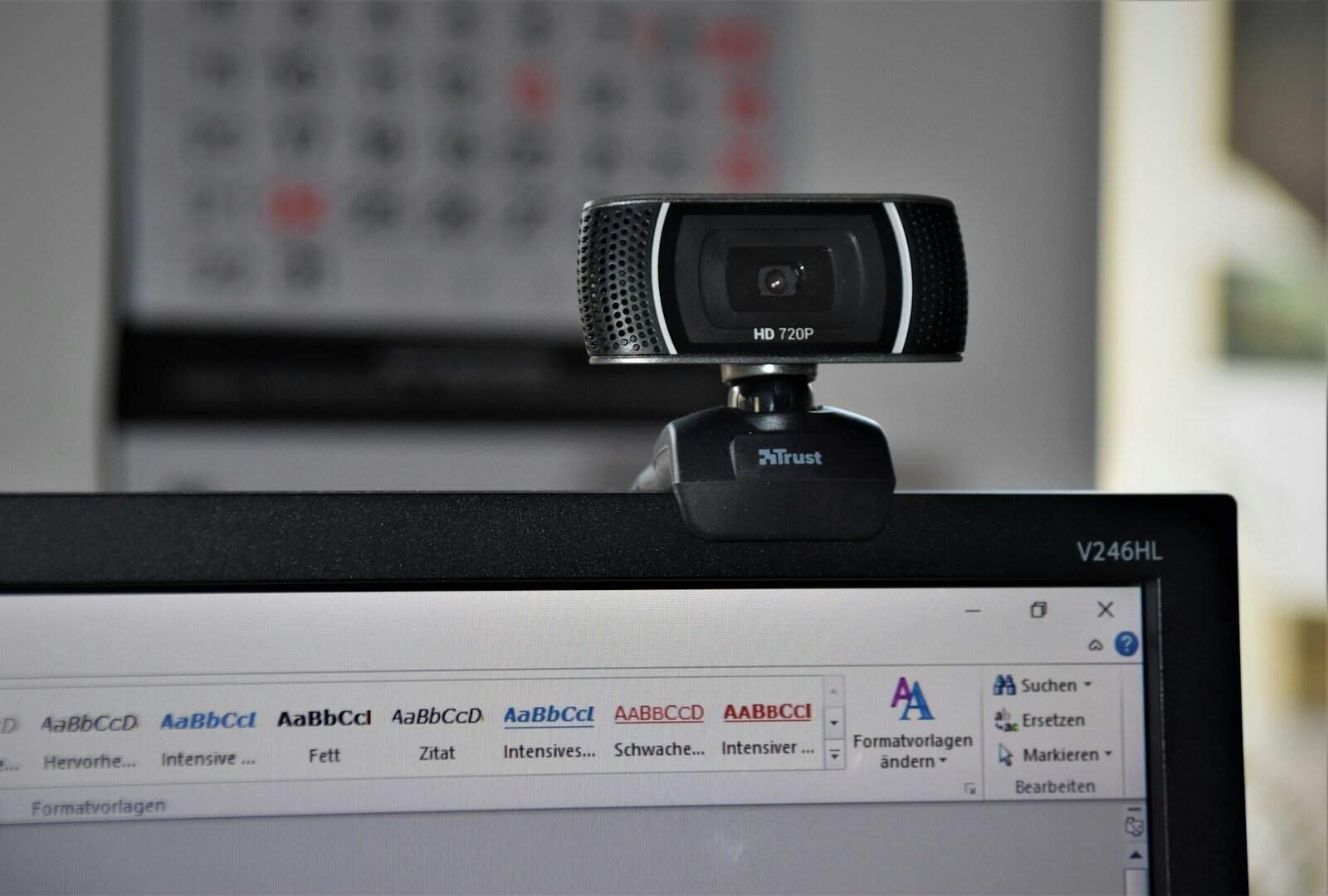 Webcam de alta definição conectada a um computador com software de edição de texto aberto, ideal para tecnologia, videoconferências e streaming.