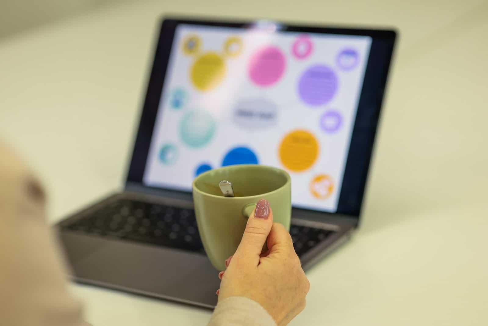 Tecnologia, computador portátil e xícara de café, ambiente de trabalho moderno.
