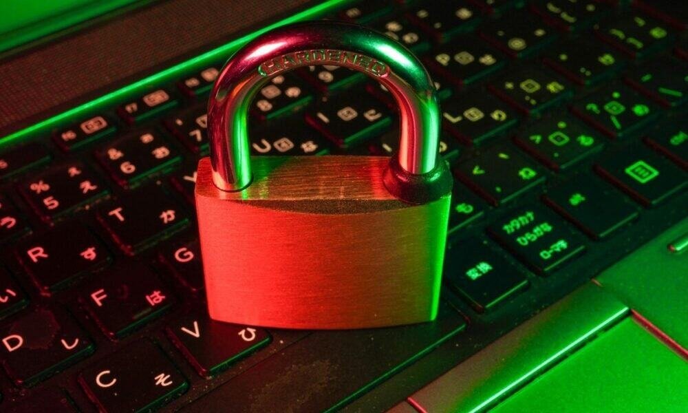 Cadeado de segurança sobre teclado de computador com iluminação LED verde e vermelho.
