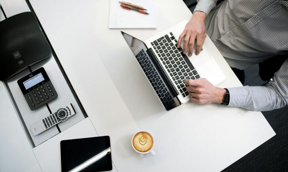 Notebooks e tecnologia no escritório com laptop, telefone, tablet e objetos de trabalho.