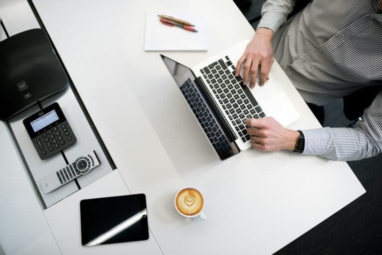 Notebooks e tecnologia no escritório com laptop, telefone, tablet e objetos de trabalho.