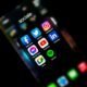 Aplicativos de redes sociais em smartphone, incluindo Facebook, Instagram, Twitter, YouTube, LinkedIn, Messenger e Spotify.