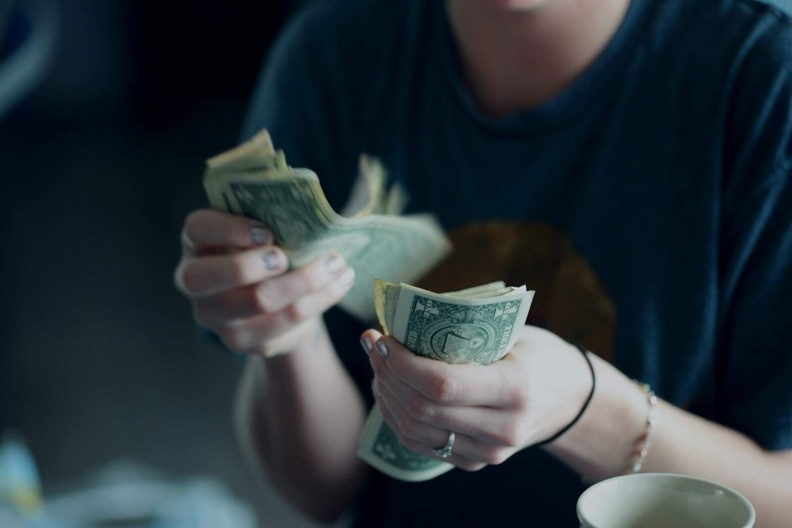 Dinheiro em papel dólar, pessoa contando notas de dólar, finanças e economia.