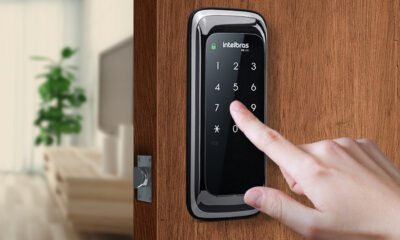 Tela de controle de acesso digital com teclado numérico em porta de madeira.