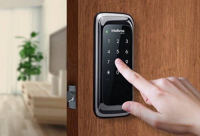 Tela de controle de acesso digital com teclado numérico em porta de madeira.