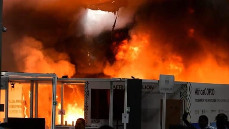 Incêndio em evento com estrutura de feira, grande chame e fumaça de fogo intenso.