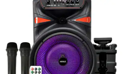 Som Bluetooth com microfones e iluminação LED roxa para eventos musicais.