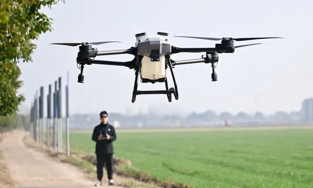 Drone de tecnologia com câmera para filmagens aéreas; piloto controlando drone com controle remoto; inovação em tecnologia de drones.