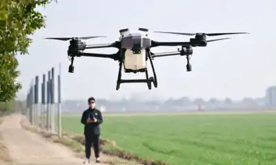 Drone de tecnologia com câmera para filmagens aéreas; piloto controlando drone com controle remoto; inovação em tecnologia de drones.