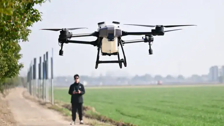Drone de tecnologia com câmera para filmagens aéreas; piloto controlando drone com controle remoto; inovação em tecnologia de drones.