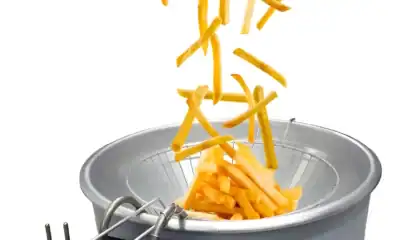 Chips de batata sendo feitos em máquina de fritar industrial.