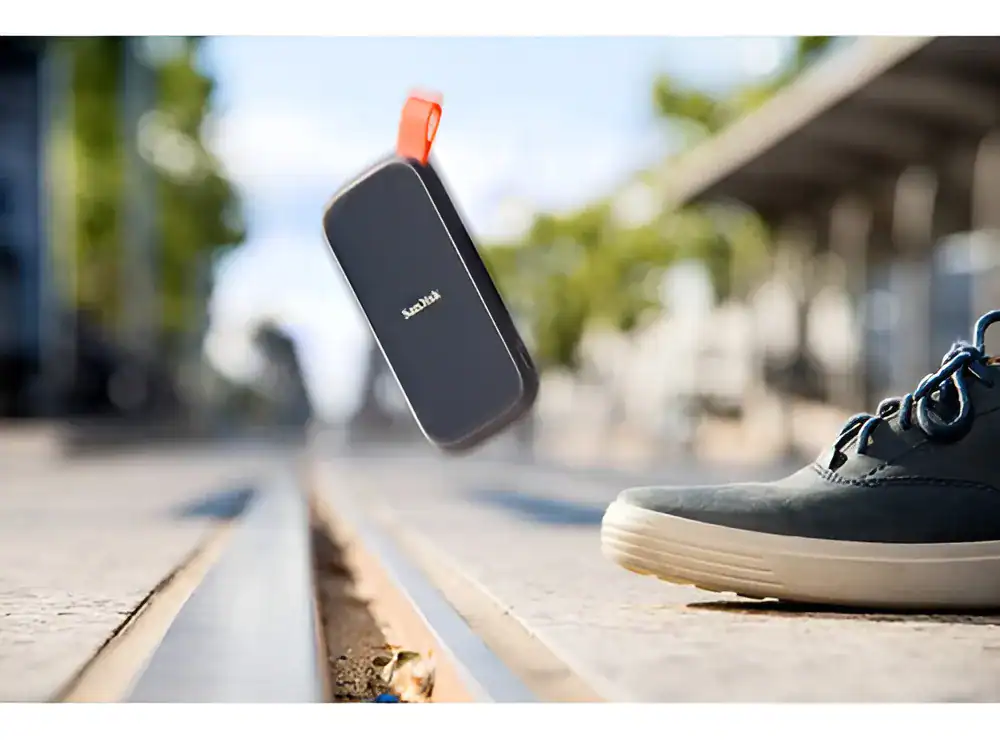 Fone Bluetooth sem fio caindo no chão ao lado de tênis esportivos.