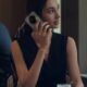 Smartphone com câmera grande em mulher usando em ambiente interior, tecnologia móvel.