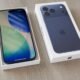 Smartphone iPhone 13 exibido na caixa com design moderno e câmeras duplas.