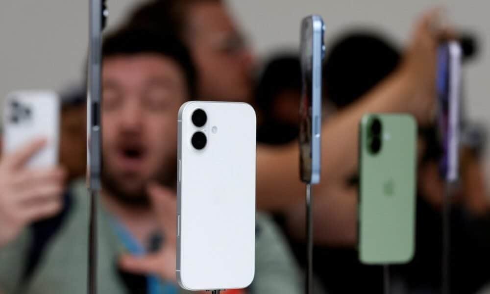Smartphone branco em exposição com vários modelos ao fundo, tecnologia de smartphones.