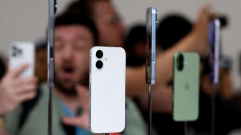 Smartphone branco em exposição com vários modelos ao fundo, tecnologia de smartphones.