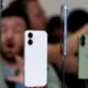 Smartphone branco em exposição com vários modelos ao fundo, tecnologia de smartphones.
