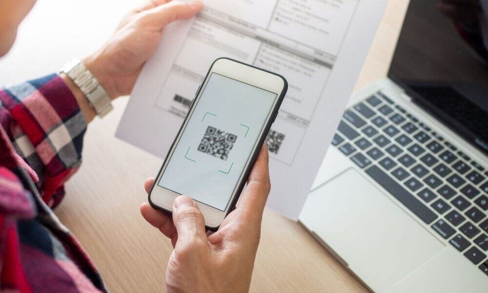 Códigos QR sendo escaneados para pagamento com smartphone.