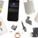Componentes de reparo de smartphones desmontados, peças internas e hardware.