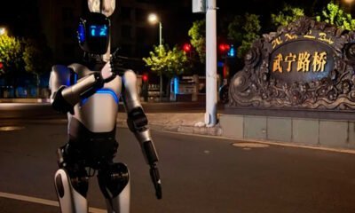 Robô humanóide futurista em rua iluminada à noite, tecnologia avançada e inovação.