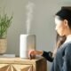 Mulher usando difusor de óleos essenciais para aromatizar o ambiente.