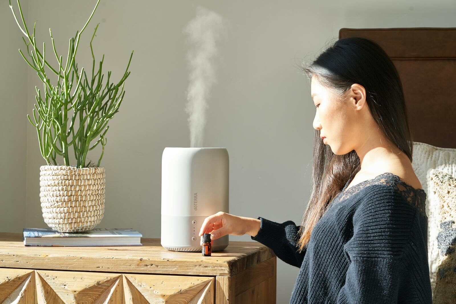 Mulher usando difusor de óleos essenciais para aromatizar o ambiente.