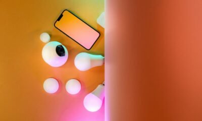 Smartphone com acessórios tecnológicos e iluminação colorida para fotos criativas.