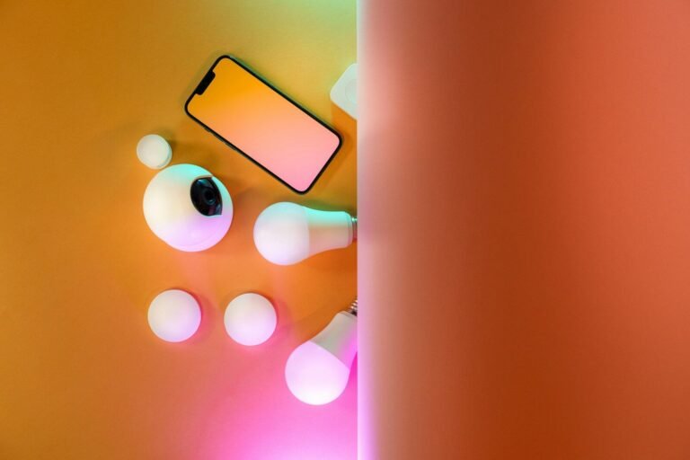 Smartphone com acessórios tecnológicos e iluminação colorida para fotos criativas.