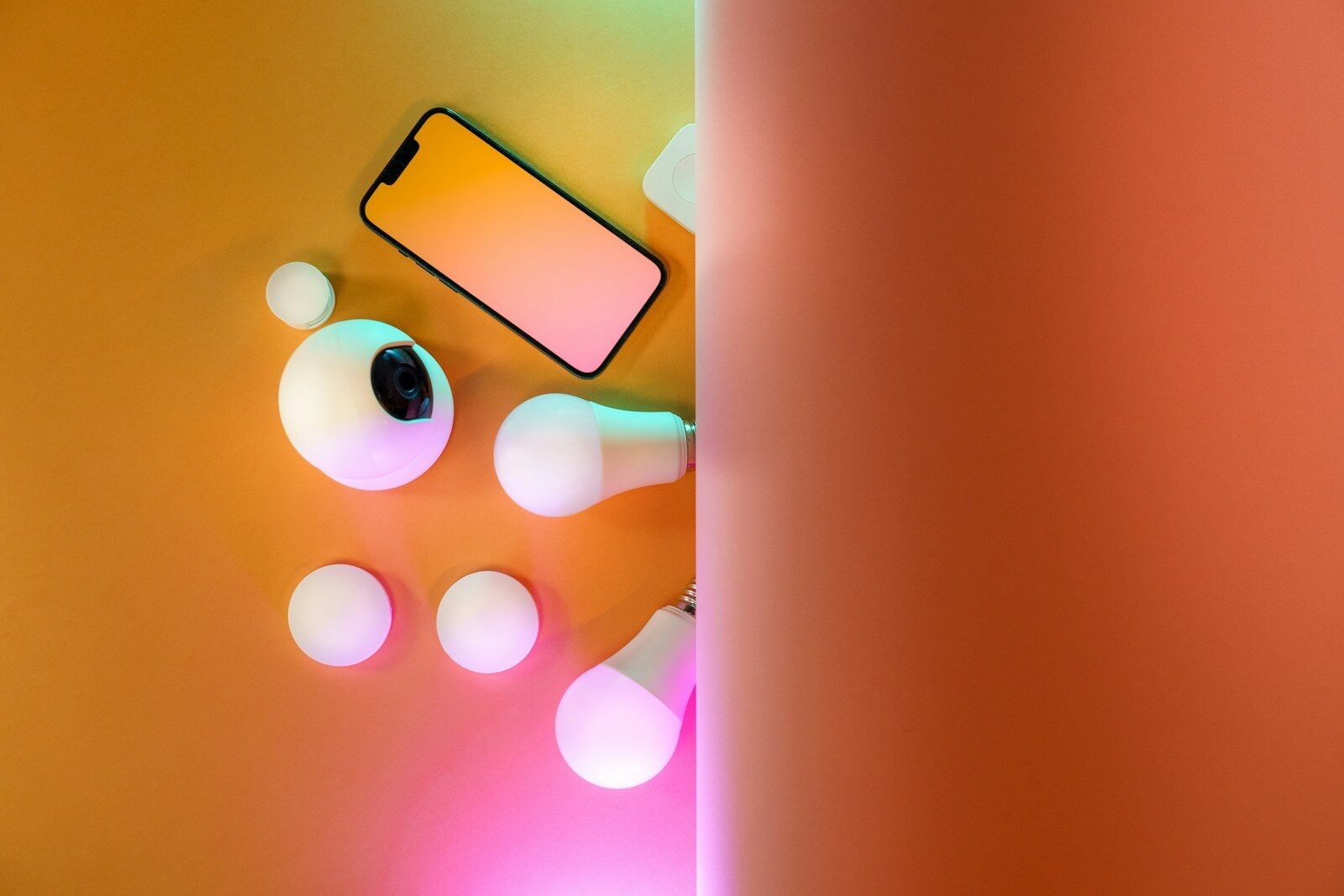 Smartphone com acessórios tecnológicos e iluminação colorida para fotos criativas.